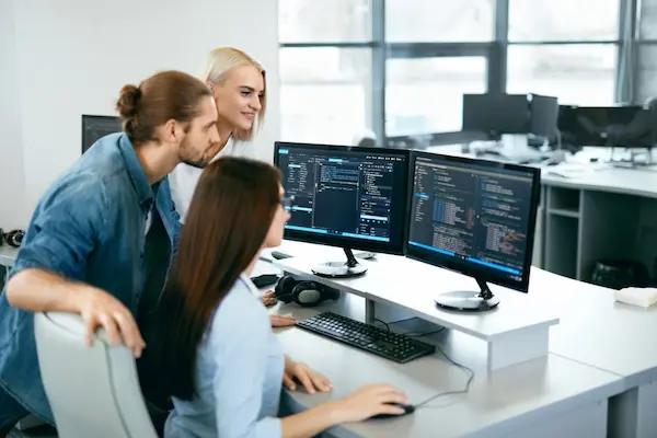 Optimización de software en equipo de trabajo colaborando frente a computadoras